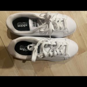 Men’s white Adidas sneakers.